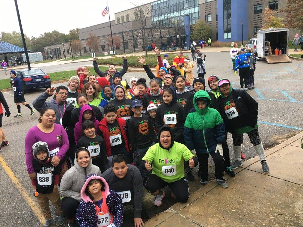 Large group of kids posing after a marathon|Cover of 2015 annual report featuring Health Fund logo