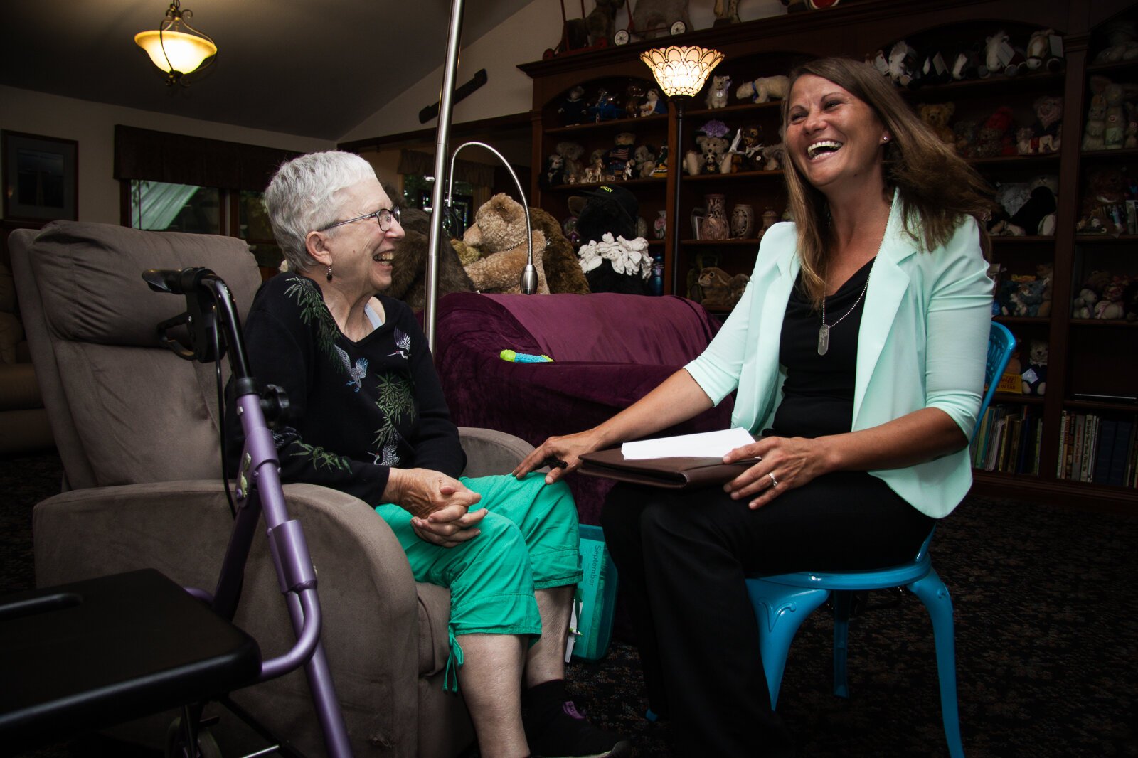 An older woman meets with a health worker in her home.